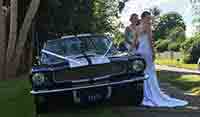 Blue Shelby 1965 Mustang Fastback with bridal models posing in photo shoot